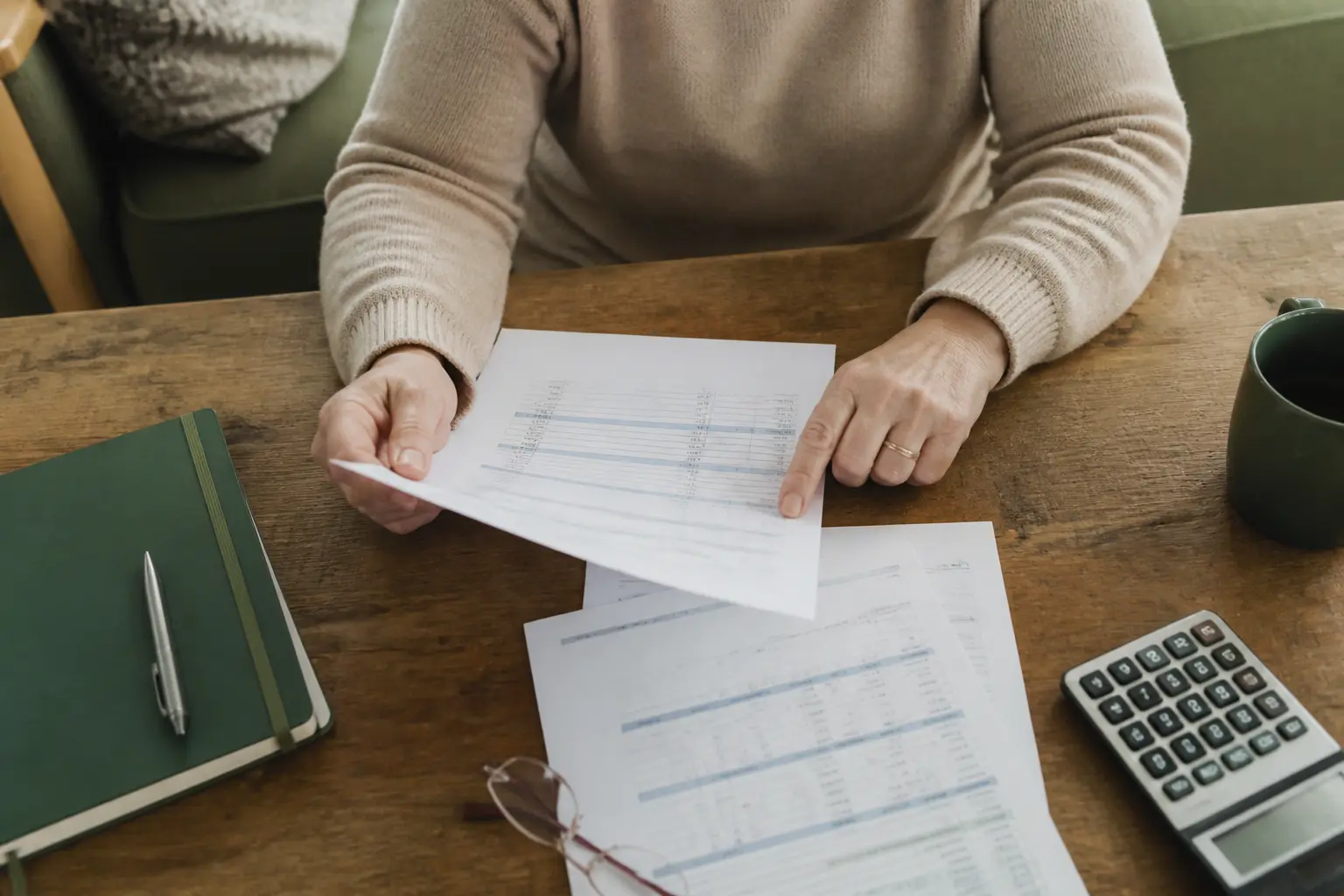 Mains examinant un budget familial à table, illustrant mon mari touche 1500 euros ai je droit au rsa dans un appartement modeste