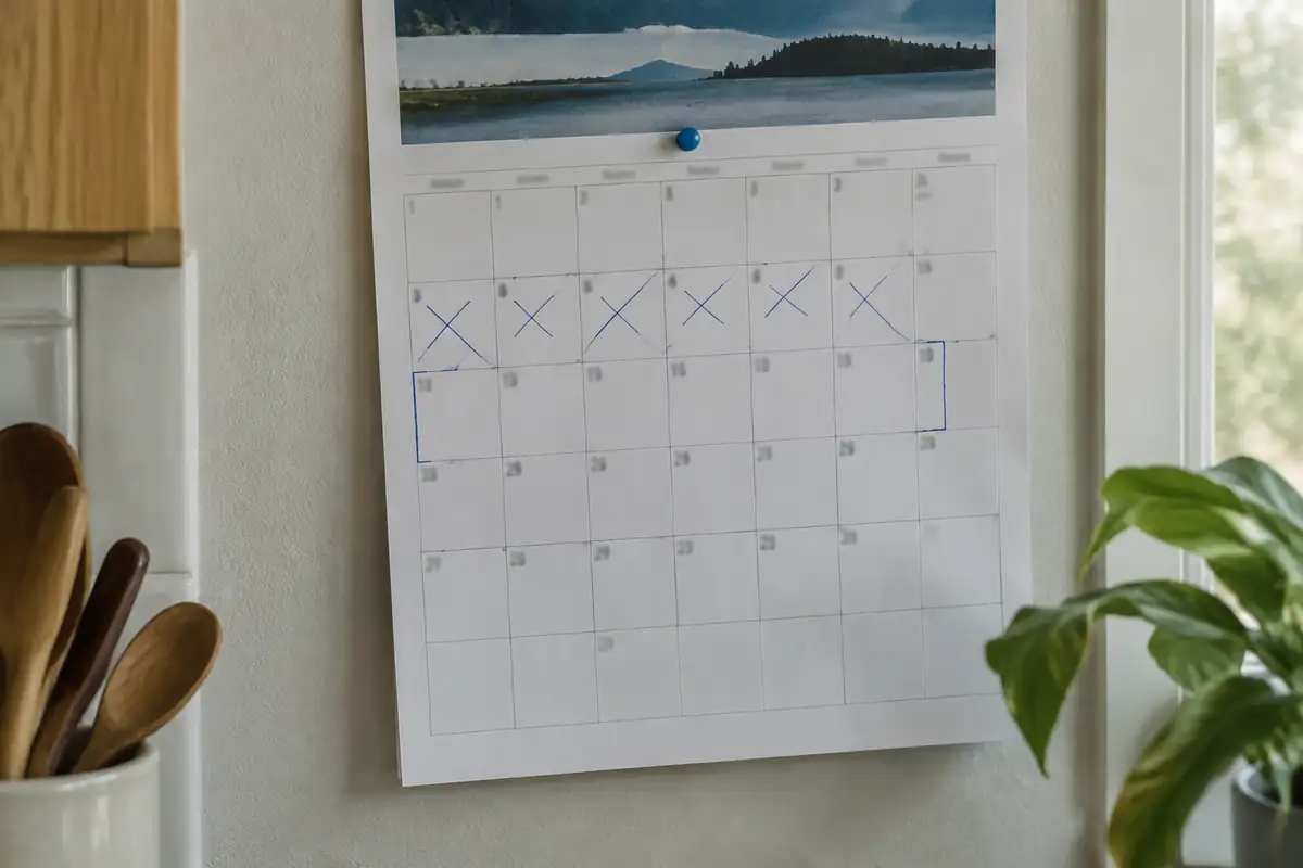 Calendrier mural avec des jours barrés et deux semaines encadrées